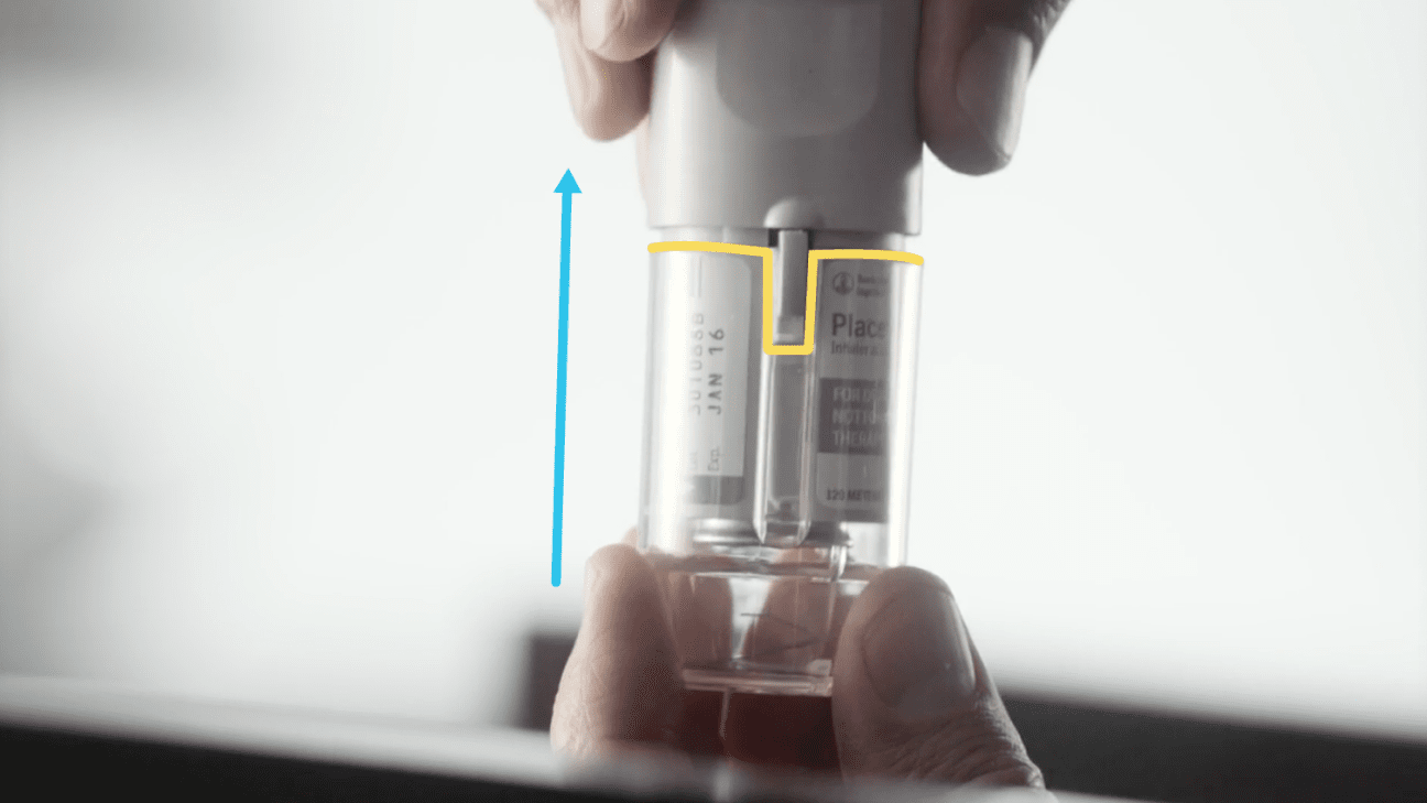 Hands pushing the clear base back onto a Respimat inhaler.