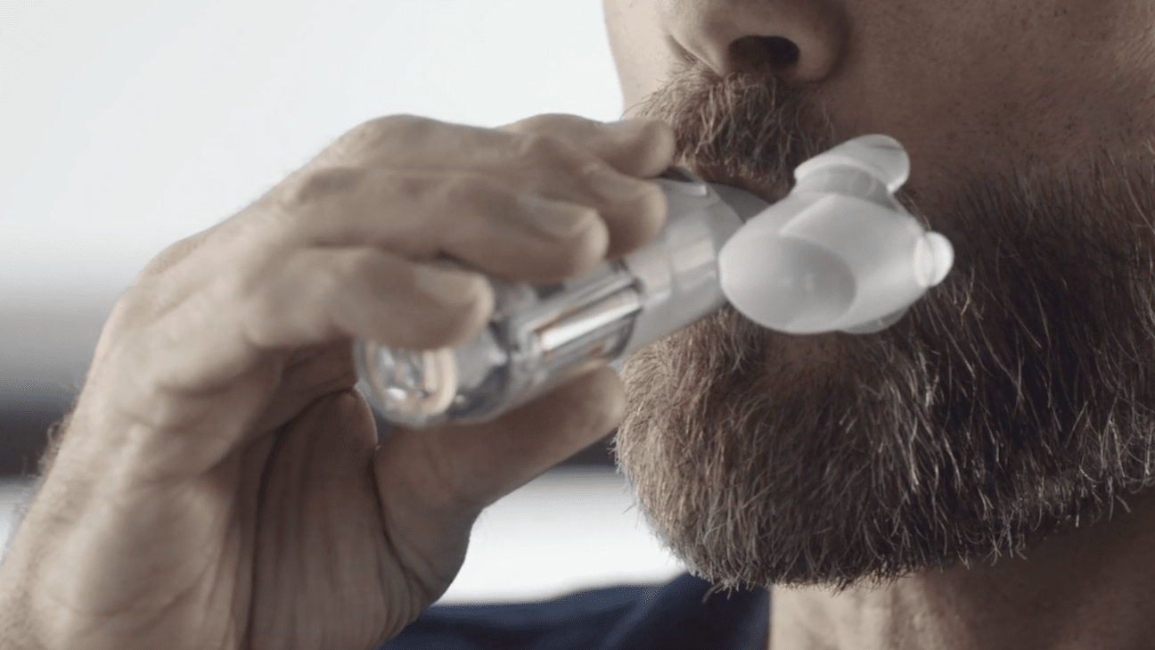 A person with the Respimat inhaler mouthpiece in their mouth,
