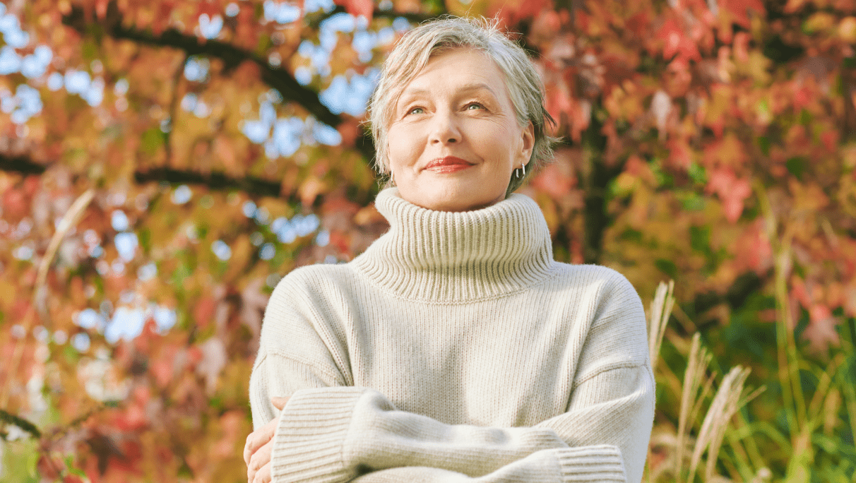 Smiling senior woman in autumn park.